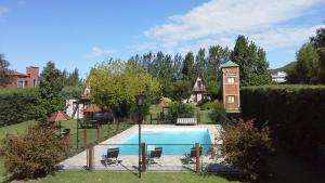 a pool in a yard with chairs and a building at Las Encinas in Potrero de los Funes