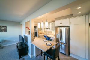 a kitchen with a table and a refrigerator at McKinnon Pointe #102 in Edmonton
