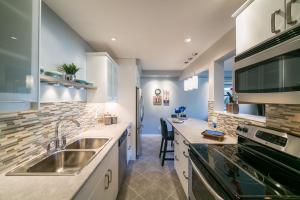 a kitchen with a sink and a stove at McKinnon Pointe #102 in Edmonton