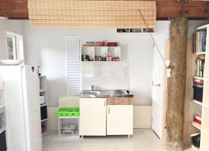 una cocina con armarios blancos y fregadero en Titirangi Paradiso, en Titirangi