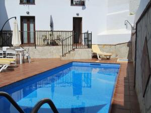 a swimming pool with a table and chairs on a balcony at Apartamento c/piscina centro Nerja in Nerja