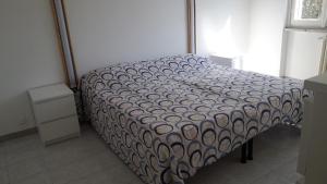 Una cama en una habitación con un edredón. en Casa Perego, en Monza