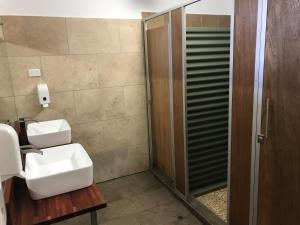 
a bathroom with a shower and a sink at Kimberley Travellers Lodge - Broome YHA in Broome
