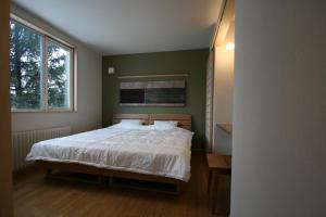 una camera con un letto e una grande finestra di Forest View a Furano