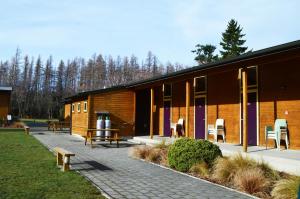 un edificio con mesas de picnic y bancos delante de él en Hanmer Springs Forest Camp Trust, en Hanmer Springs