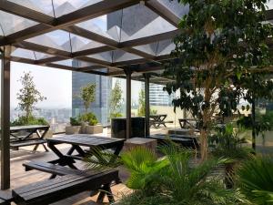 un patio con mesas de picnic y vistas a la ciudad en Suites Capri Reforma Ángel 380, en Ciudad de México