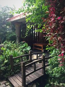 a garden with a wooden bridge and a bench at Hotel Middle Path & Spa in Pokhara