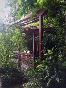 a wooden pergola with a bench in a garden at Hotel Middle Path & Spa in Pokhara