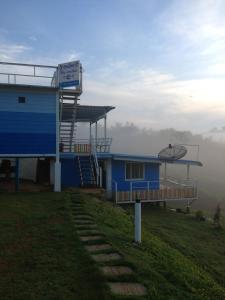 a blue building on the top of a hill at Charmtalamok Khaokho Resort in Ban Khao Ya Nua