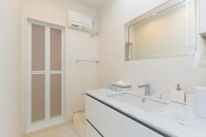 a white bathroom with a sink and a mirror at Guest Villa Hakone Miyanoshita in Hakone +53 photos