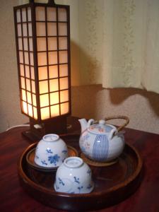 a table with two tea pots and a lamp on it at Kasuga Ryokan in Hiroshima