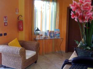 ein Wohnzimmer mit einem Sofa und einem Tisch mit Blumen in der Unterkunft Hotel Altamarea in San Vito lo Capo