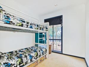 a bedroom with bunk beds and a window at Sea Devine - Port Willunga - C21 SouthCoast Holidays in Port Willunga +5 photos