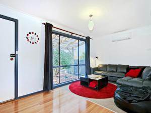 a living room with a black leather couch and a table at Sea Devine - Port Willunga - C21 SouthCoast Holidays in Port Willunga