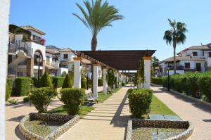 una pasarela con una palmera y edificios en Al-andalus Residencial, en Vera