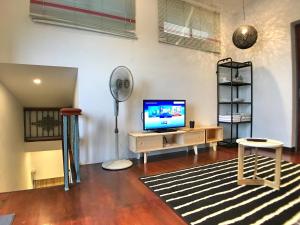 ein Wohnzimmer mit einem TV und einem Ventilator in der Unterkunft iBook Gurney Suites in George Town