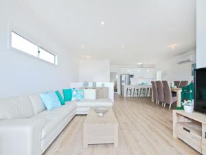 a living room with a white couch and a table at Seas the Day - Aldinga Beach - C21 SouthCoast Holidays in Aldinga Beach