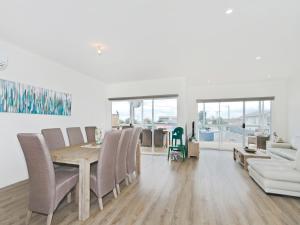 a dining room with a table and chairs and a couch at Seas the Day - Aldinga Beach - C21 SouthCoast Holidays in Aldinga Beach