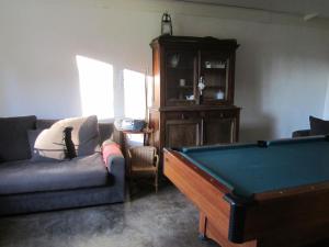 a living room with a couch and a pool table at Ferme Cacheterie, boutique terroir in Fleury-la-Forêt