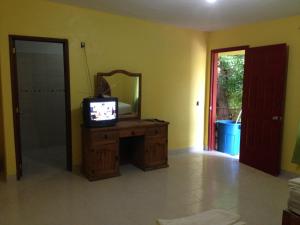 Habitación con espejo y mesa con TV. en Hotel Posada Andaluz, en Xochitepec