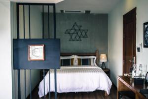 a bedroom with a bed and a green wall at Lavanya Boutique Hotel in Phnom Penh