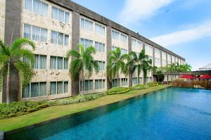 a building with a swimming pool in front of a building at ASTON Denpasar Hotel & Convention in Denpasar