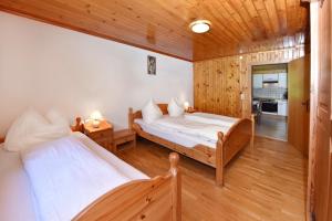 two beds in a room with wooden walls at Haus Brügga in Brand