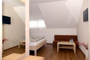 Cette chambre comprend un lit, un canapé et une table. dans l'établissement Restaurace Obůrka, à Blansko