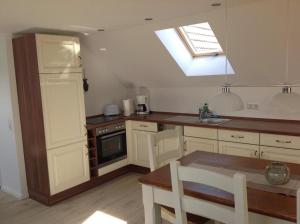 a kitchen with white cabinets and a skylight at Haus Irma in Zingst
