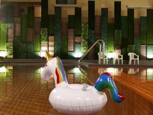 a pool with an inflatable unicorn and a swimming pool at The Pat Hotel in Jomtien Beach