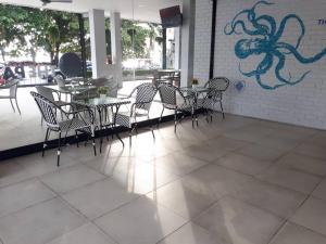 un patio avec des chaises et des tables ainsi qu'un mur orné d'une fresque murale. dans l'établissement The Pat Hotel, à Jomtien Beach