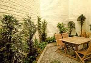 a wooden table and two chairs in a garden at De Mot B&B in Brussels