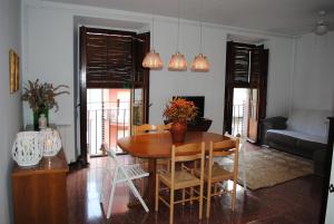 sala de estar con mesa de madera y sillas en Casa 1627, en Blanes
