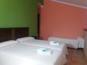 two beds in a room with green and orange walls at Hospedería Prepirineo in Undués-Pintano