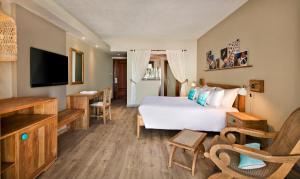 a hotel room with a bed and a flat screen tv at C Mauritius in Belle Mare