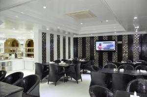a dining room with black chairs and tables and a television at White Fort Hotel in Dubai