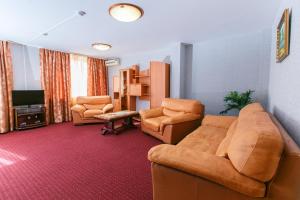 a living room with a couch and chairs and a television at Hotel Central (Vostok) in Birobidzhan