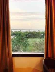 a window in a train with a view of a field at The Park Residency in Greater Noida