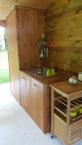 a wooden kitchen with a sink and a counter at Chalet au Coeur de Foret Gouvieux in Gouvieux