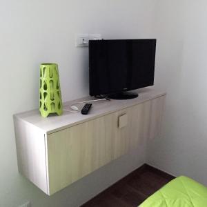 una televisione in cima a un comò in una stanza di Appartamenti Morena CIR 0043-CIR 0044 ad Aosta