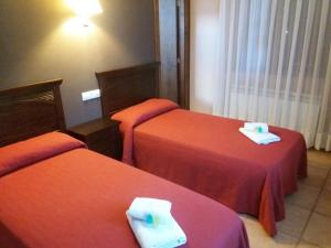a hotel room with two beds with towels on them at Hospedería Prepirineo in Undués-Pintano