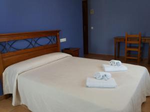 a bedroom with a bed with two towels on it at Hospedería Prepirineo in Undués-Pintano