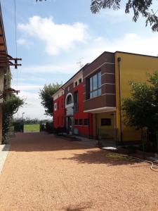 CavriagoにあるDolce Vita Lovely Suitesの畑の隣の赤と黄色の建物