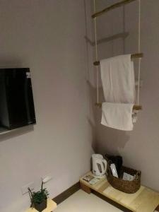 La salle de bains est pourvue d'un sèche-serviettes, d'une télévision et de serviettes. dans l'établissement Woods Decor - Anping, à Tainan