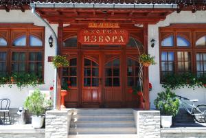 a facade of a building with a wooden door at Family Hotel Izvora in Tryavna