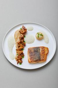 a white plate of food with toast and bacon at Strandhotel Fontana in Timmendorfer Strand