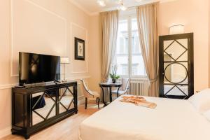 a bedroom with a bed and a flat screen tv at Relais Tosinghi in Florence