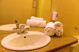 a bathroom with a sink and towels on a counter at Nurtau in Pavlodar +51 photos