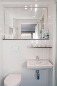uma casa de banho com um lavatório, um WC e um espelho. em Smartappart Caen Grusse em Caen