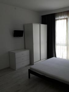 カバルジンカにあるApartment Porto Heliのベッドルーム1室(ベッド1台、ドレッサー、窓付)